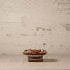 Decorative ceramic knob on a textured surface with a neutral background
