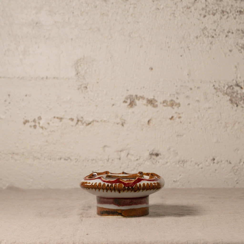 Decorative ceramic knob on a textured surface with a neutral background