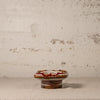 Small ceramic knob with decorative patterns on a textured surface