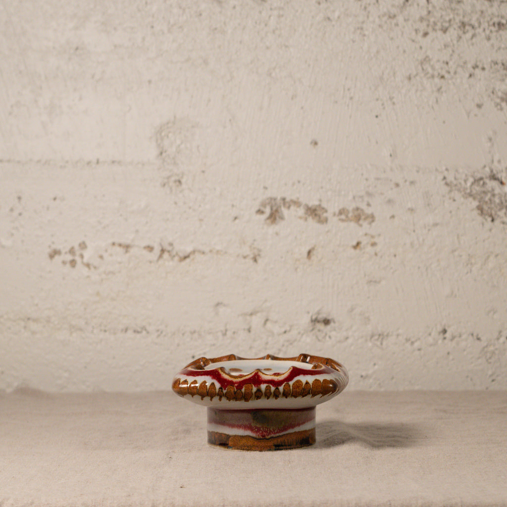 Small ceramic knob with decorative patterns on a textured surface
