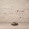 Small ceramic dish with floral design on a textured surface