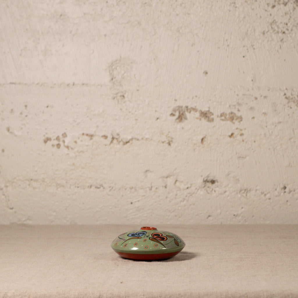 Small ceramic dish with floral design on a textured surface