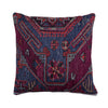 A square throw pillow featuring a detailed, vintage-style geometric and floral pattern in deep navy blue, magenta, and red, set against a plain off-white background.