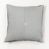 A square gray throw pillow with a central seam and a small white fabric tag, shown against a plain white background.