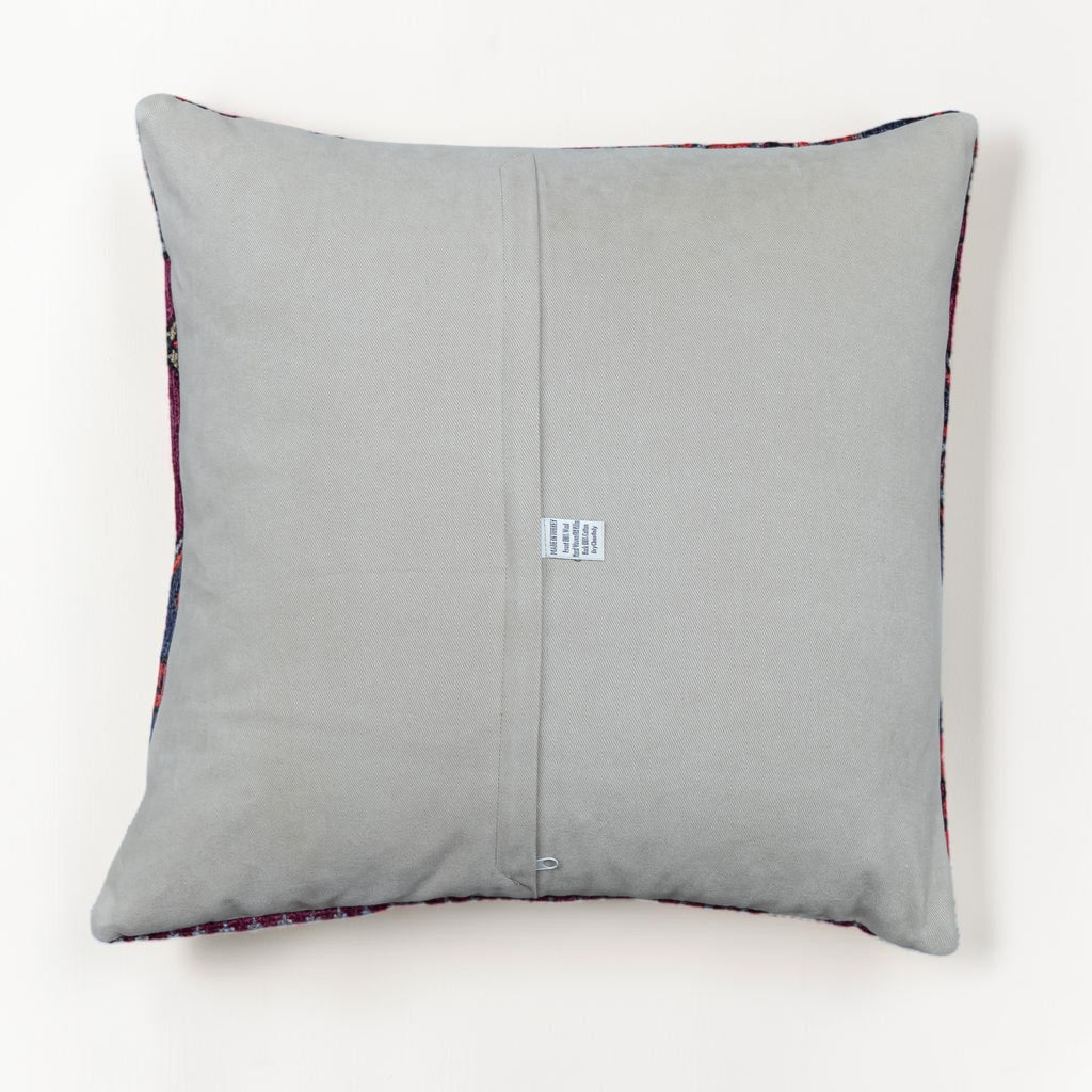 A square gray throw pillow with a central seam and a small white fabric tag, shown against a plain white background.