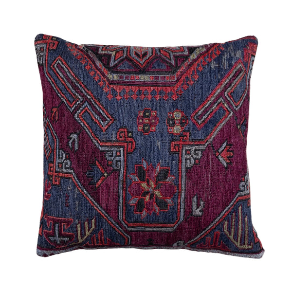 A square throw pillow featuring a detailed, vintage-style geometric and floral pattern in deep navy blue, magenta, and red, set against a plain off-white background.