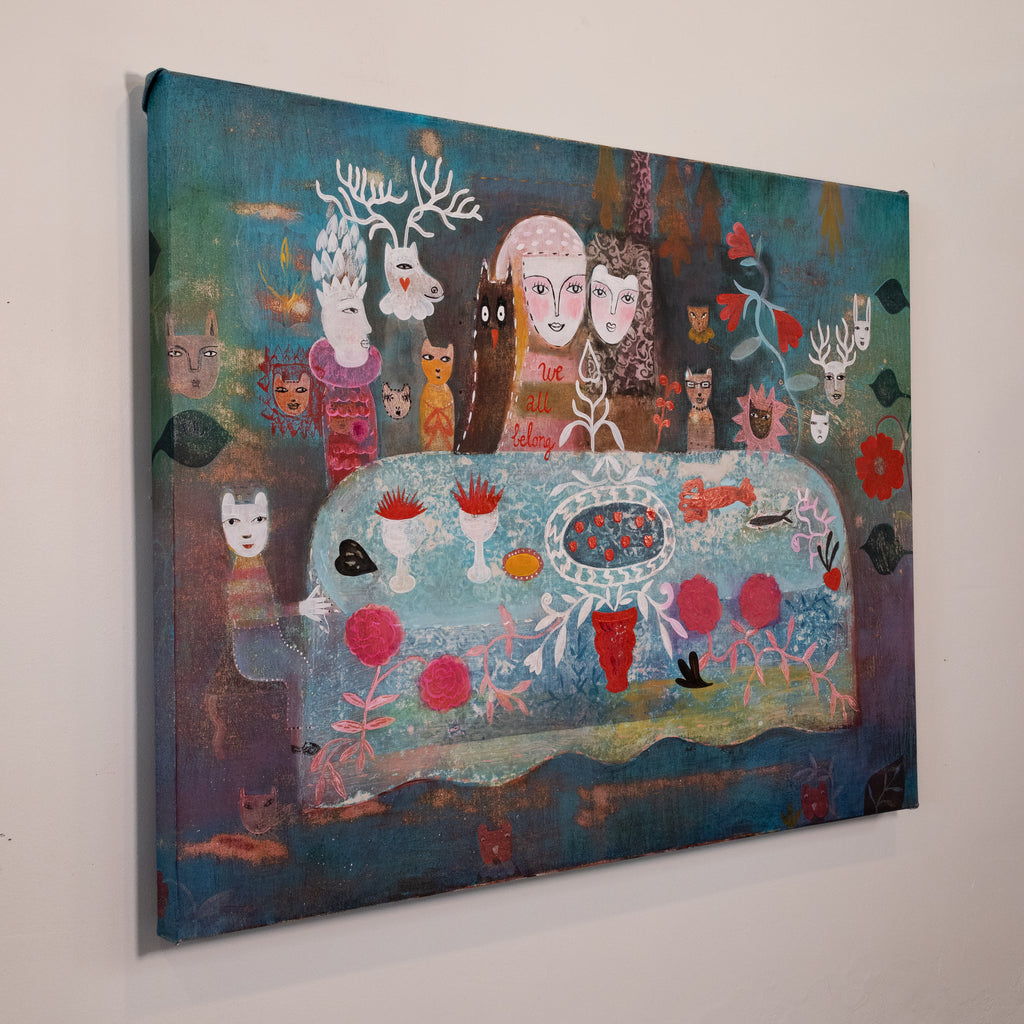 A square canvas painting hanging on a light gray wall, featuring a surreal, colorful scene with faces, animals, flowers, and abstract elements in blue, teal, pink, red, cream, and brown tones.