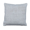 A square throw pillow in a textured, woven off-white fabric, displayed flat on a rustic gray wooden plank floor.