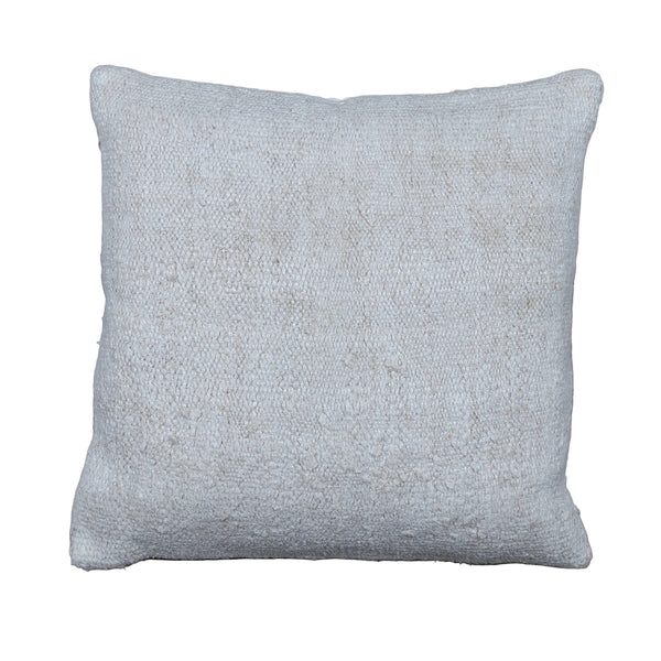 A square throw pillow in a textured, woven off-white fabric, displayed flat on a rustic gray wooden plank floor.