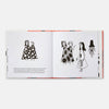 Open book with illustrations of women in polka dot dresses on a white background
