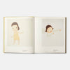 Open book with illustrations of a child in a yellow dress on a white background