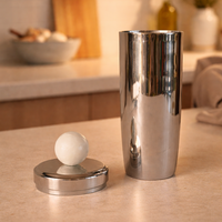 Metallic shaker and ball on a kitchen counter with blurred background