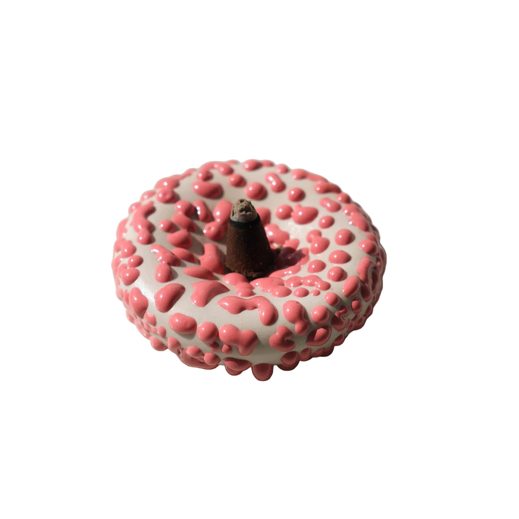 Pink textured incense holder on a white background