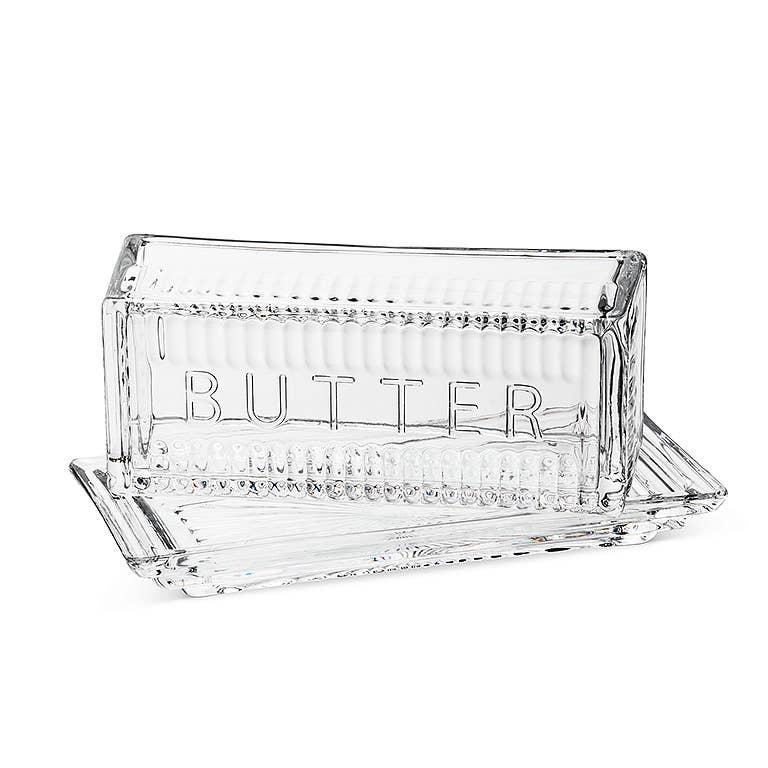 Clear glass butter dish with 'BUTTER' engraving on a white background