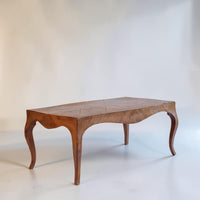 A vintage wooden coffee table with a herringbone patterned top and curved cabriole-style legs, photographed against a plain off-white studio background.