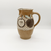 Ceramic pitcher with apple design on a white background