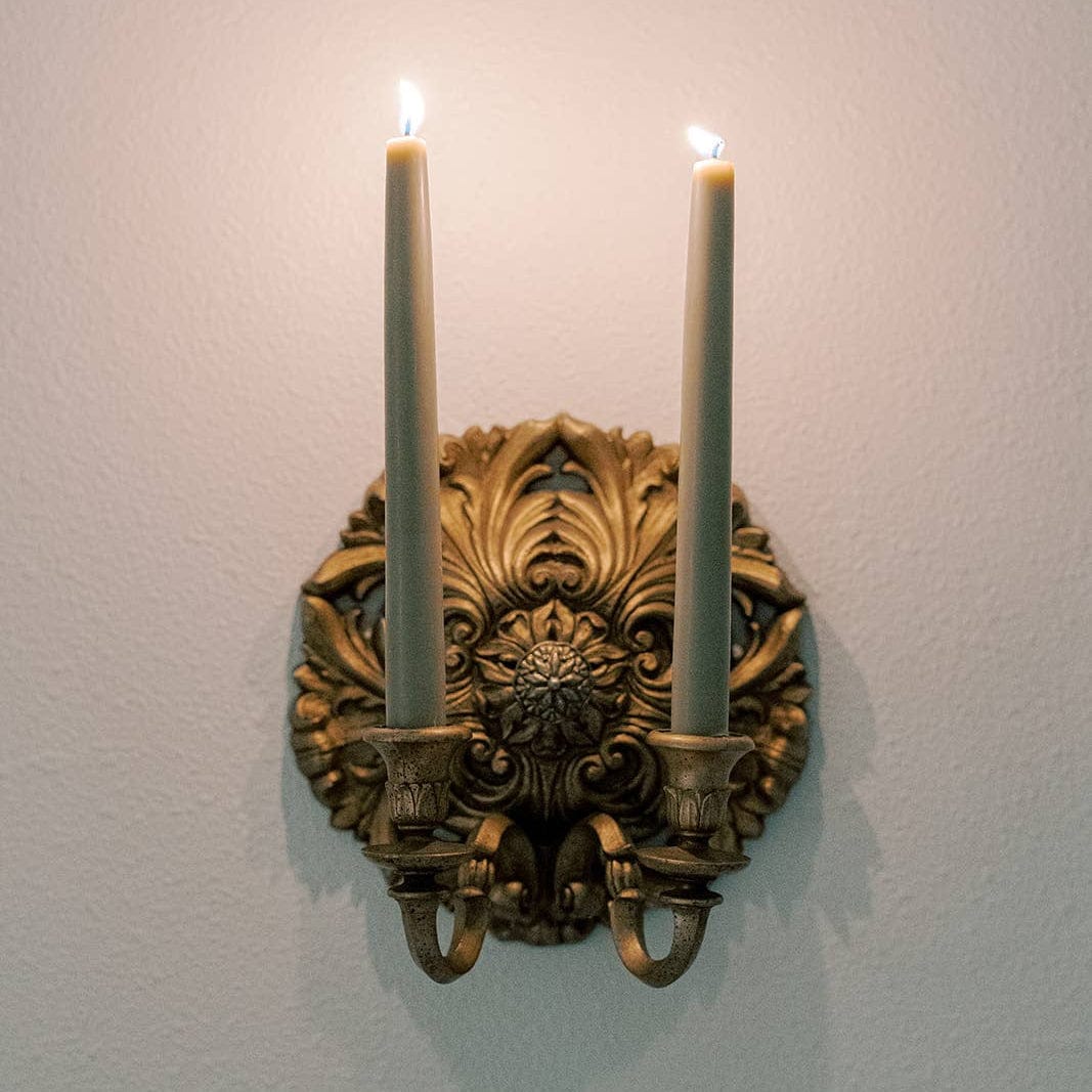 Candle sconce with two lit candles.