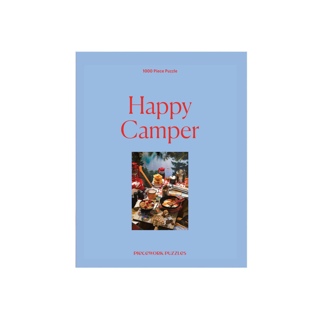 Puzzle box titled 'Happy Camper' with a blue cover and photo of a camper interior.