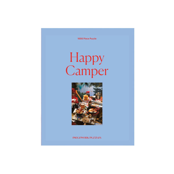 Puzzle box titled 'Happy Camper' with a blue cover and photo of a camper interior.