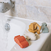 Colorful bath toys on a bathtub with a neutral background