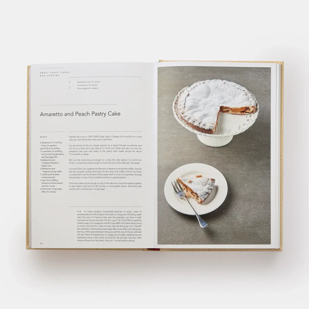 Open cookbook showing a recipe for Amaretto and Peach Pastry Cake with a slice of cake on a plate.
