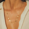 Gold necklace with circular pendants on a person