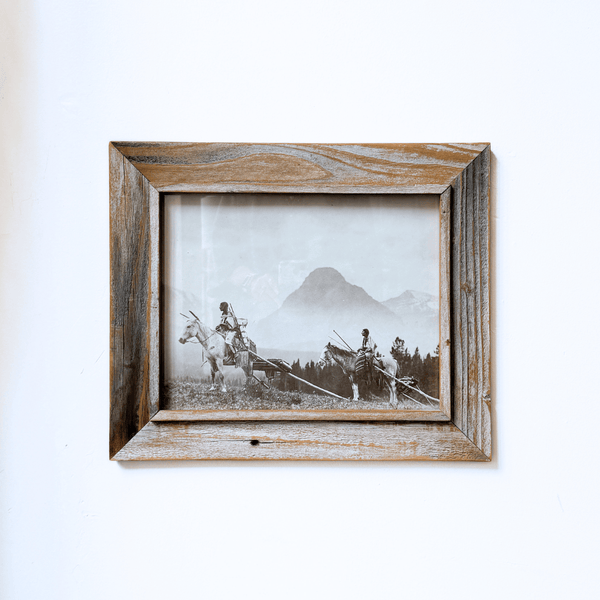 Framed black and white photograph of a person on horseback with mountains in the background.