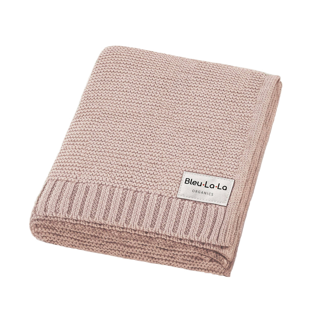 Pink knitted blanket with a label on a white background