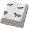 Folded blanket with sheep pattern and 'Bleu-La-La' label on a white background