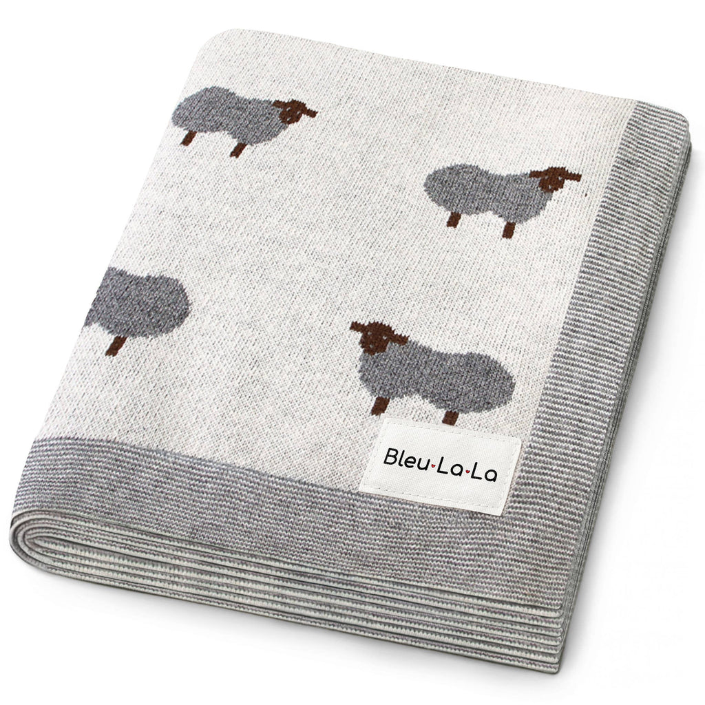 Folded blanket with sheep pattern and 'Bleu-La-La' label on a white background