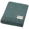 Teal knit blanket with 'Bleu La La Organics' label on a white background