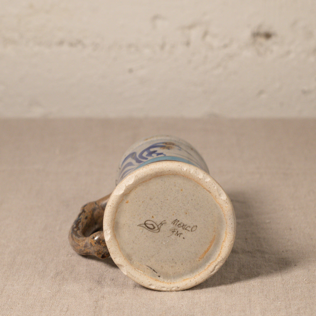Ceramic mug with blue design on beige surface and textured background