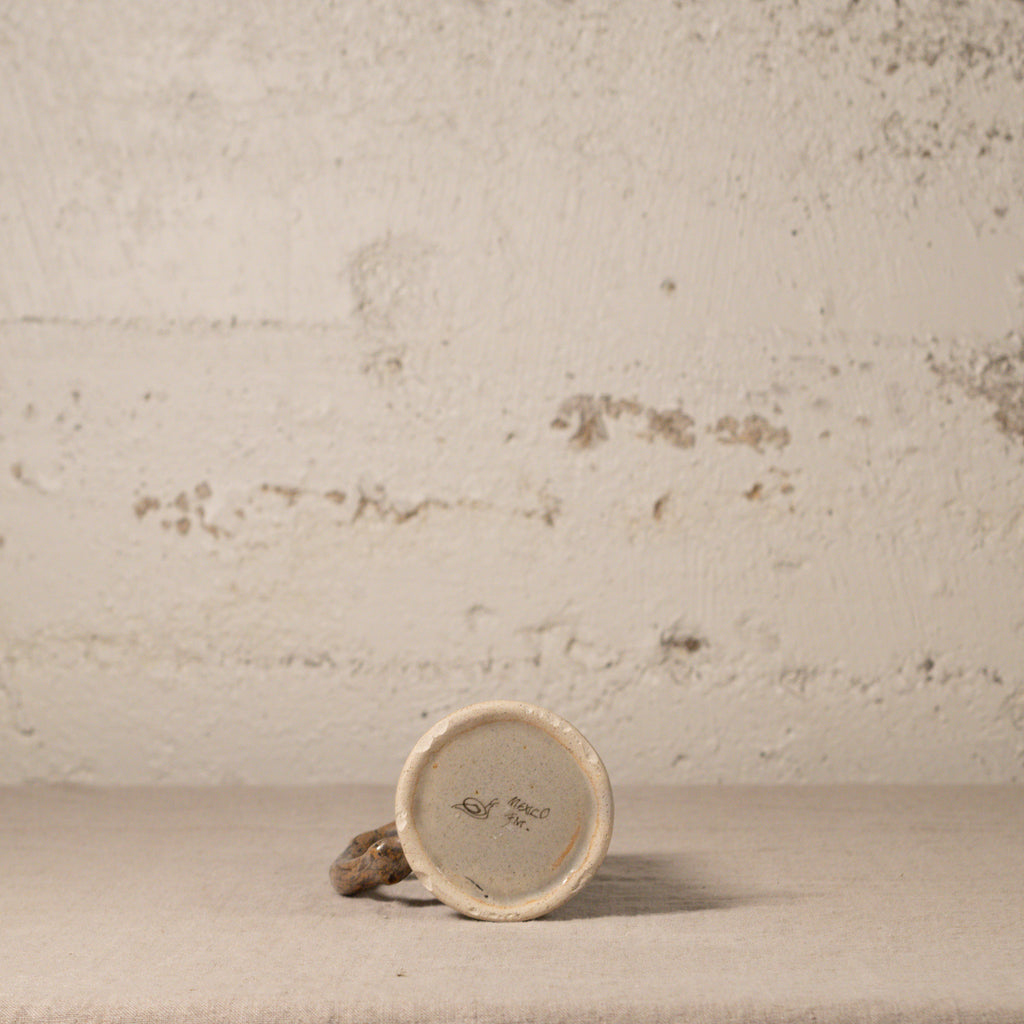 Small ceramic object with a textured surface on a beige background