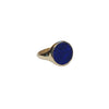 Gold ring with a blue stone on a light gray background