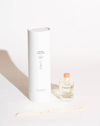 Candle and diffuser set with a white box on a light background