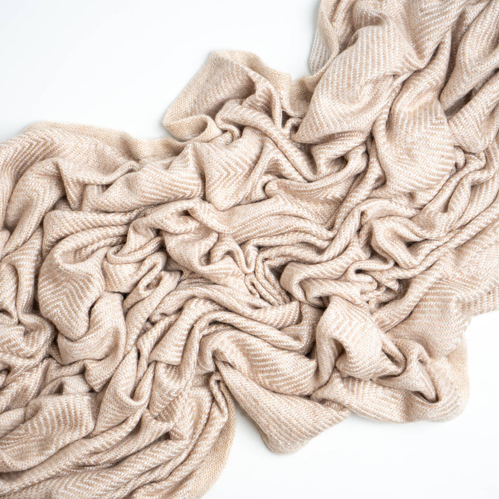 cream colored cashmere blanket on white background