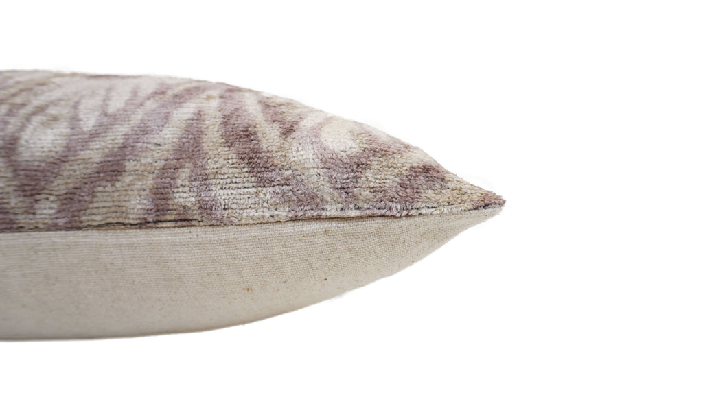 Close-up of a decorative pillow with a patterned top and white bottom.