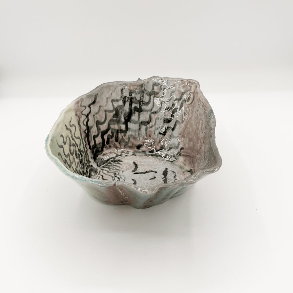 Handmade ceramic bowl with textured surface on a white background