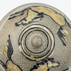 Ceramic dish with horse illustrations and concentric circle design on a textured beige background