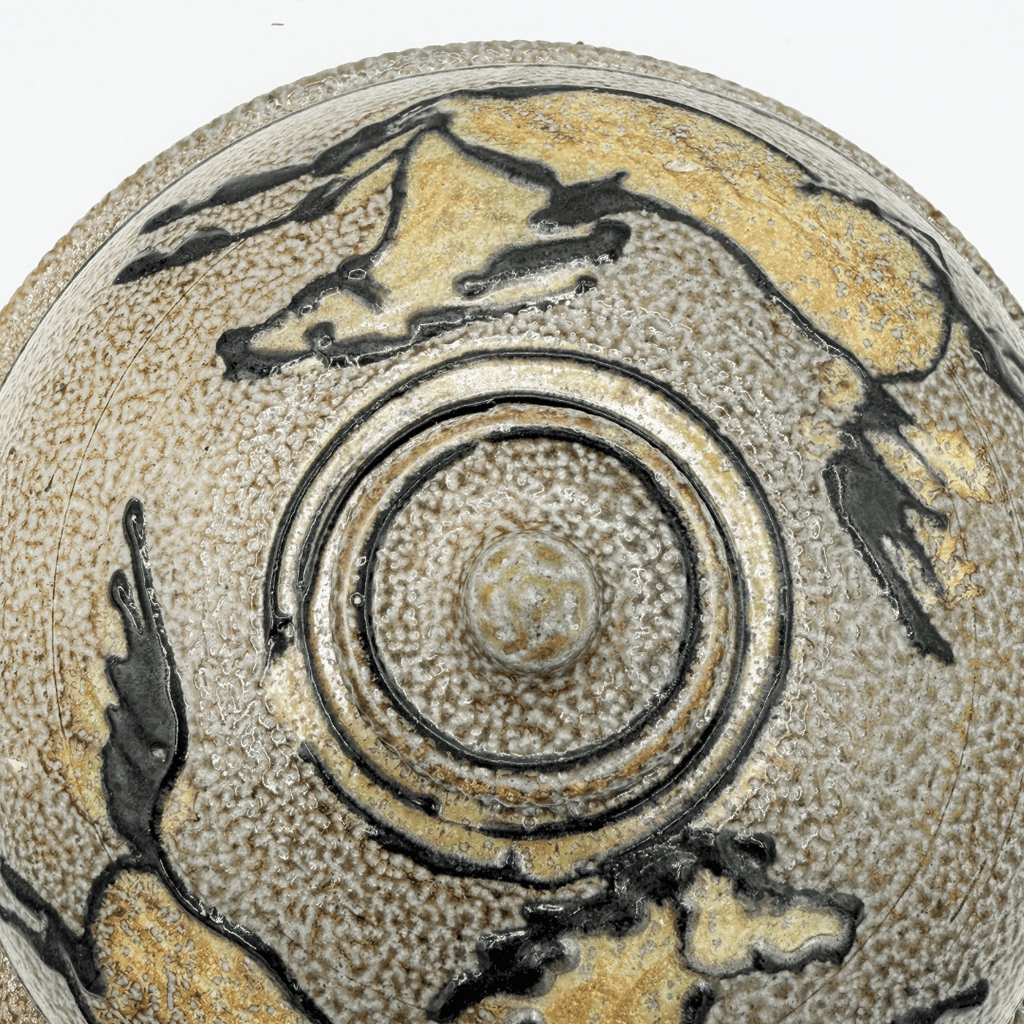 Ceramic dish with horse illustrations and concentric circle design on a textured beige background