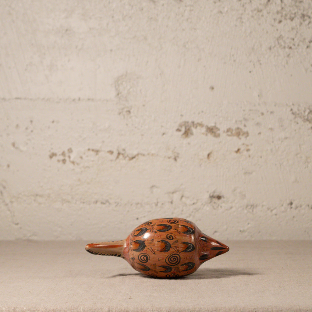 Decorative ceramic object with spiral patterns on a textured surface