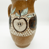 Ceramic pitcher with apple design on a white background