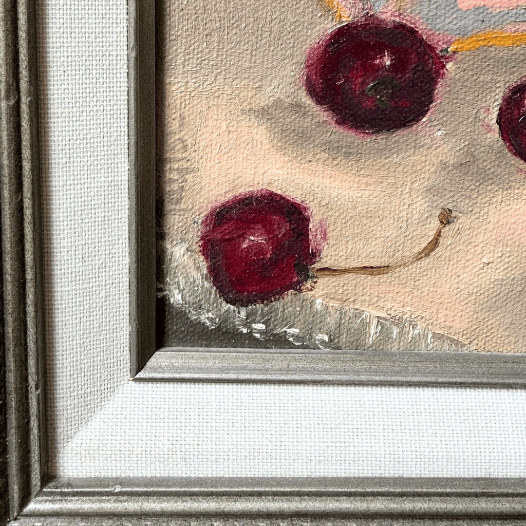 Framed artwork of cherries on a textured surface