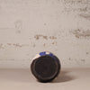 Ceramic vase with blue and white pattern on a textured beige surface