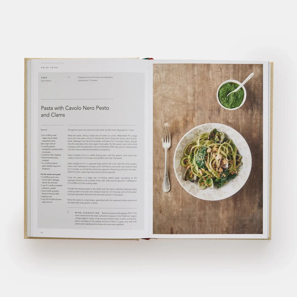 Open cookbook showing a recipe for Pasta with Cavolo Nero Pesto and Clams on a wooden surface.