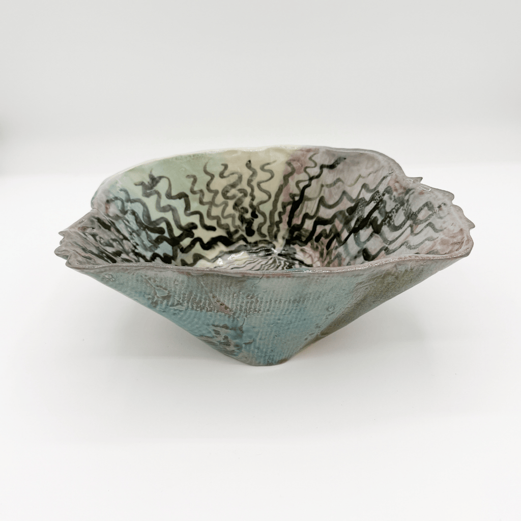 Ceramic bowl with textured surface and wavy patterns on a white background