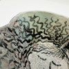 Close-up of a ceramic bowl with wavy black lines on a white background