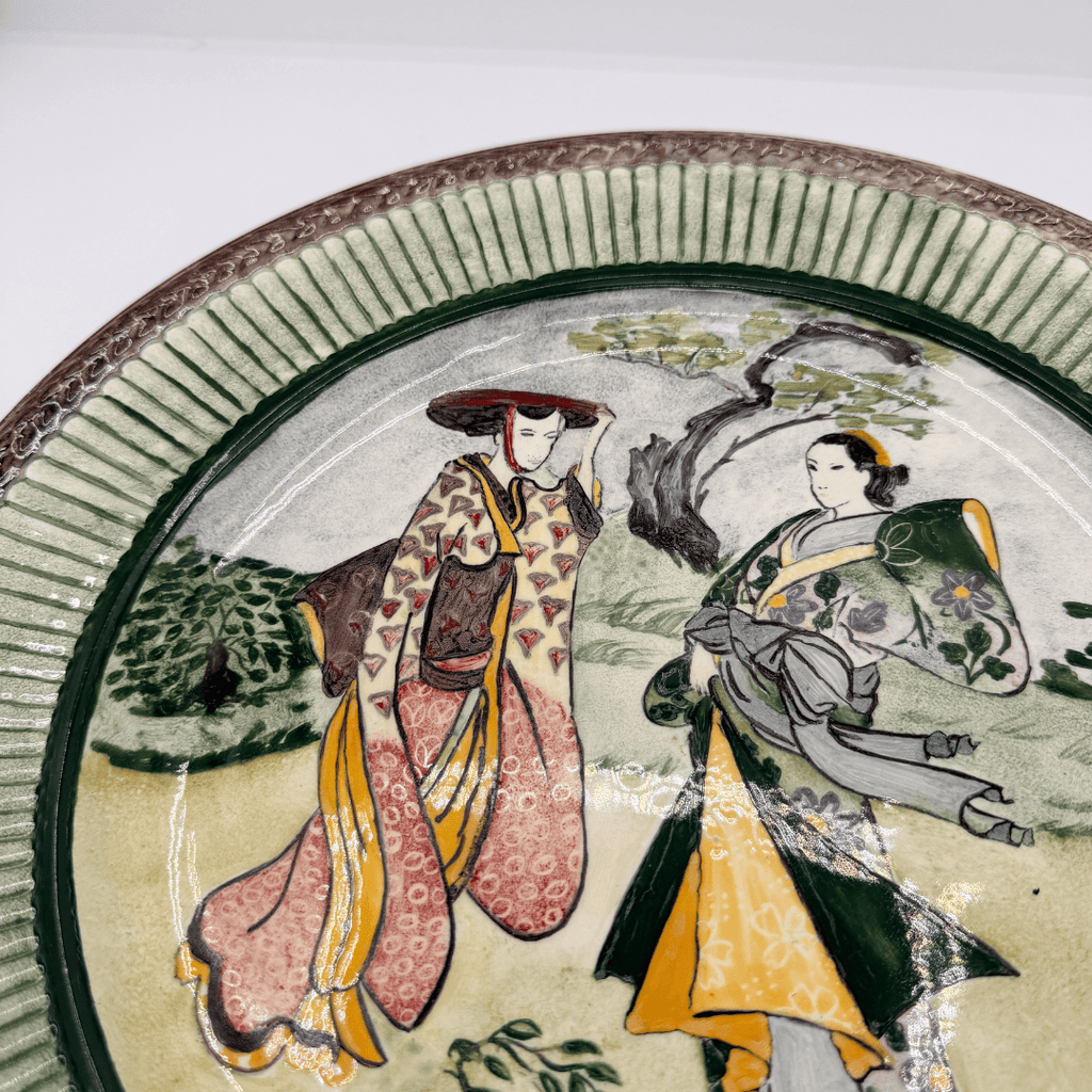 Ceramic plate with traditional Japanese scene of two women in kimono.