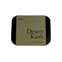 A square metal tin of Dilo Desert Kush incense cones, featuring a tan paper label with black text, set against a plain white background.