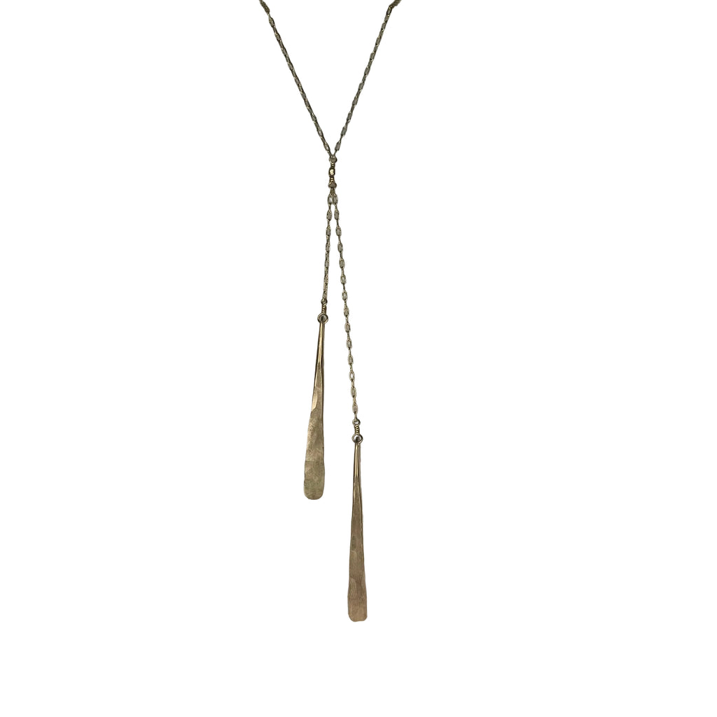 Long necklace with a pendant on a textured stone surface